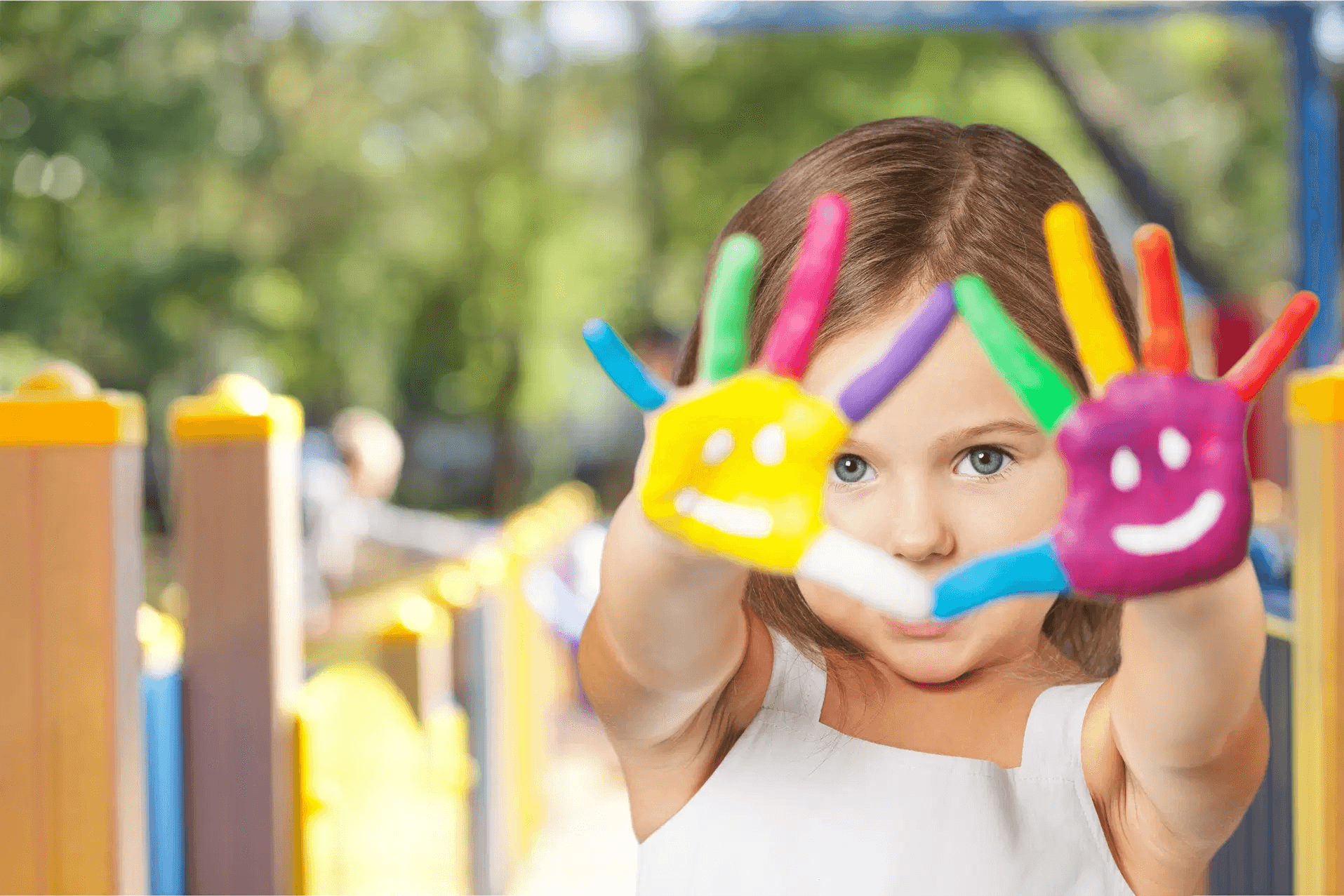 Girl holding up colourfully-painted hands